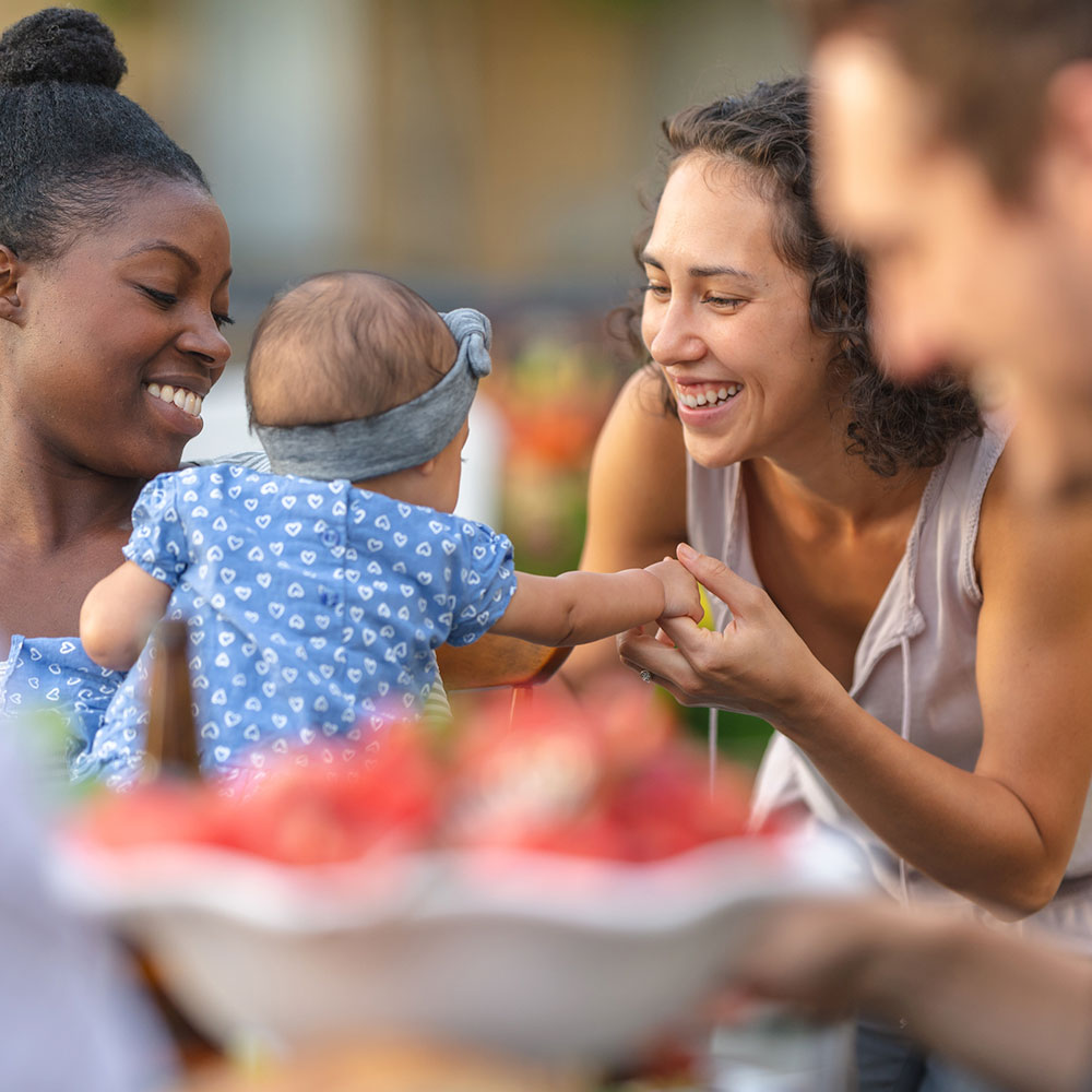 Social gathering with men, women, baby, and food.