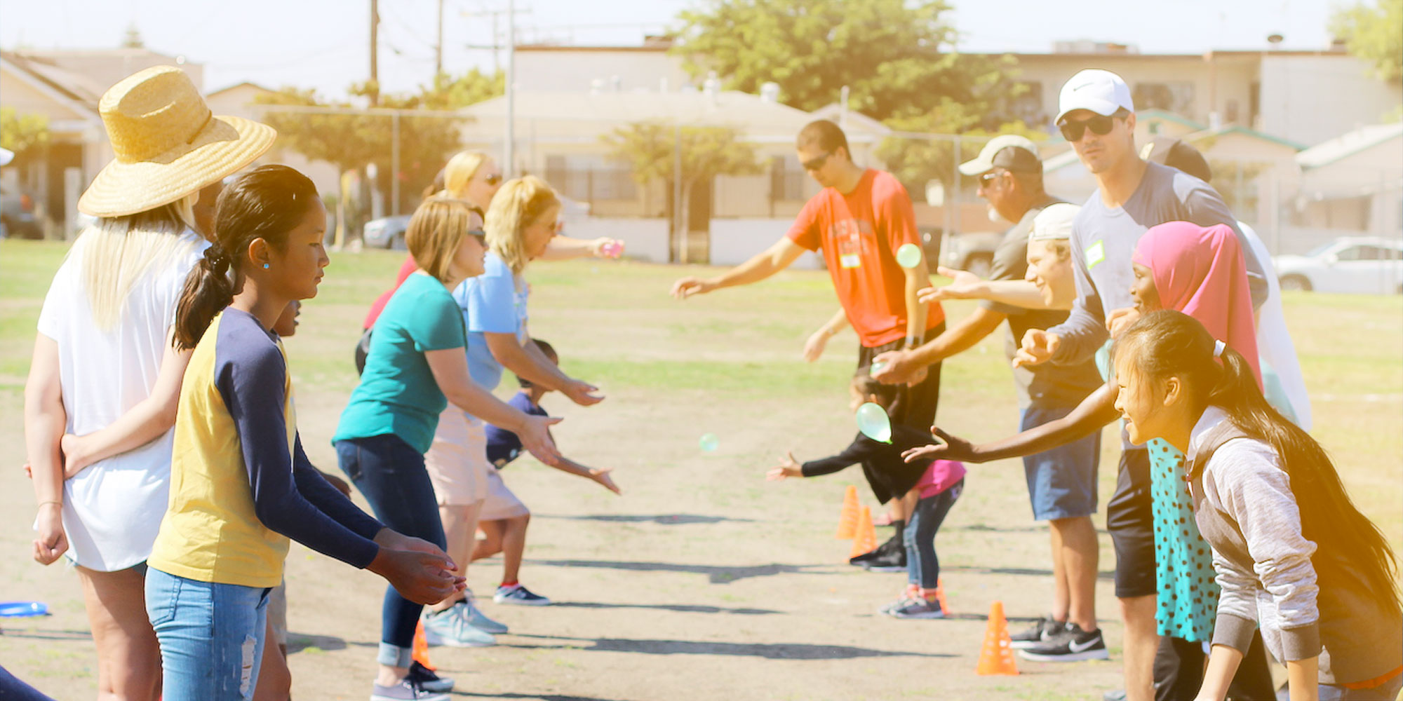 Community of people playing a balloon toss game at the local park